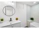 Bathroom with modern sink, round mirror, stylish fixtures, and bathtub at 2996 S Sheridan Blvd, Denver, CO 80227