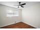 Cozy bedroom featuring hardwood floors, a ceiling fan, and a bright window providing ample natural light at 2996 S Sheridan Blvd, Denver, CO 80227