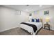 A cozy bedroom is carpeted and has a large bed, with natural light coming from the two windows at 2996 S Sheridan Blvd, Denver, CO 80227