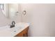 A well-lit powder room featuring a vanity, granite countertop, and round mirror at 1001 Victor St, Aurora, CO 80011