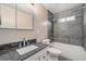 Bathroom with granite countertop, vanity, and tiled tub with glass door at 1001 Victor St, Aurora, CO 80011