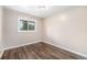 Bright bedroom featuring hardwood floors, neutral paint, and a single window with view of outdoors at 1001 Victor St, Aurora, CO 80011
