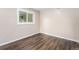 Cozy bedroom featuring hardwood floors, neutral paint, and a view of the outdoors from the window at 1001 Victor St, Aurora, CO 80011