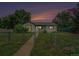 Charming single-story home with a fenced yard and mature trees, set against a picturesque evening sky at 1001 Victor St, Aurora, CO 80011