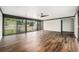 Spacious living room featuring hardwood floors, a ceiling fan, and large windows for natural light at 1001 Victor St, Aurora, CO 80011