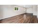 Spacious living room with beautiful wood-look floors and abundant natural light from two windows at 1001 Victor St, Aurora, CO 80011