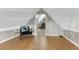 Cozy attic room with neutral walls, unique cork flooring, and a decorative chair and small table at 1729 N Clarkson St, Denver, CO 80218