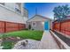 Charming backyard featuring a well-maintained lawn, garden beds, and a detached garage with a vibrant blue door at 1729 N Clarkson St, Denver, CO 80218