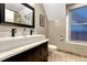 Elegant bathroom featuring a dark wood vanity, a sleek white sink, and a large window with blinds at 1729 N Clarkson St, Denver, CO 80218