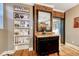 Hallway with hardwood floors, shelving, cabinet with mirror and exposed brick wall at 1729 N Clarkson St, Denver, CO 80218