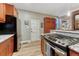 Updated kitchen featuring stainless appliances, granite counters, tile backsplash, and access to the exterior at 1729 N Clarkson St, Denver, CO 80218
