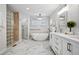 Bright bathroom featuring marble tile floors, soaking tub, glass shower, and double vanity at 467 Harrison St, Denver, CO 80206