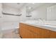 Bathroom with white tiled walls, wood vanity, and shower-tub combo at 467 Harrison St, Denver, CO 80206
