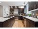 Contemporary kitchen featuring stainless steel appliances, a large island with seating, and sleek dark wood cabinetry at 467 Harrison St, Denver, CO 80206