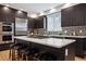 Modern kitchen with stainless steel appliances, dark wood cabinets, and a center island with ample counter space at 467 Harrison St, Denver, CO 80206