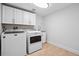 Laundry room featuring white cabinetry, washer, dryer and sink at 467 Harrison St, Denver, CO 80206