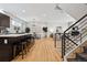 Open floor plan with hardwood floors, a kitchen island with seating, and a modern staircase at 467 Harrison St, Denver, CO 80206