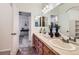 Bathroom featuring double sinks, tiled floors, and a peek into the Primary bedroom suite at 15501 E 112Th Ave # 15C, Commerce City, CO 80022