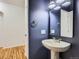 A powder bathroom featuring updated fixtures, a pedestal sink, and bold navy blue paint at 15501 E 112Th Ave # 15C, Commerce City, CO 80022