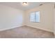 This bedroom features neutral carpet, white walls, and a window at 15501 E 112Th Ave # 15C, Commerce City, CO 80022