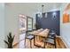 Well-lit dining room featuring modern lighting fixtures, a wood table set, and an open door to the patio at 15501 E 112Th Ave # 15C, Commerce City, CO 80022