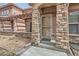 Close-up of the home's entrance featuring stone pillars, a covered porch, and a screen door at 15501 E 112Th Ave # 15C, Commerce City, CO 80022