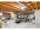 Spacious basement featuring exposed wood rafters, concrete floor, and modern furniture at 7193 S Newport Way, Centennial, CO 80112