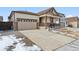 Two-car garage and a covered front porch with stone accents at 9661 Ceylon St, Commerce City, CO 80022