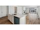 Modern kitchen with island, white cabinets, and quartz countertops at 9661 Ceylon St, Commerce City, CO 80022