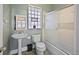 Bright bathroom with pedestal sink, glass block window, and a sliding glass door shower at 321 S Gilpin St, Denver, CO 80209