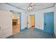 Bedroom with a ceiling fan, blue carpet, and doorways into other rooms at 321 S Gilpin St, Denver, CO 80209