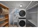Laundry area with stacked washer and dryer, shelving, and utility sink at 321 S Gilpin St, Denver, CO 80209