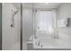 Bright bathroom featuring a shower with glass door and white soaking tub by a window at 5957 N Orleans St, Aurora, CO 80019