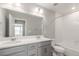 A full bathroom with double sinks, a tub, a shower, and light gray cabinetry at 5957 N Orleans St, Aurora, CO 80019