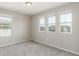 A carpeted bedroom with three windows providing lots of natural light at 5957 N Orleans St, Aurora, CO 80019