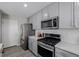 Modern kitchen with gray cabinets, stainless steel appliances, and island at 5957 N Orleans St, Aurora, CO 80019