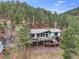 Stunning aerial view of a home nestled amidst lush greenery, showcasing its spacious deck and tranquil setting at 994 Timber Ln, Boulder, CO 80304