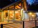 Charming home exterior featuring a deck, large windows, and a warm, inviting ambiance at night at 994 Timber Ln, Boulder, CO 80304