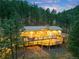 Rear exterior showcasing a spacious deck, hot tub, and large windows offering stunning views of the surrounding forest at 994 Timber Ln, Boulder, CO 80304
