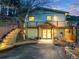 Inviting home exterior with illuminated stairway, a covered entryway, and a well-manicured front yard at 994 Timber Ln, Boulder, CO 80304