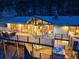 Stunning home exterior with wrap-around deck, hot tub, and wooded views at twilight at 994 Timber Ln, Boulder, CO 80304