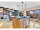Kitchen island with stone counters, wood cabinetry, and stainless appliances overlooks dining and living areas at 994 Timber Ln, Boulder, CO 80304