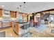 Open kitchen boasts wooden cabinetry, stone countertops, stainless appliances and flows to the living area at 994 Timber Ln, Boulder, CO 80304