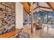 Spacious living room featuring a stone accent wall, vaulted ceilings, and scenic views from large picture windows at 994 Timber Ln, Boulder, CO 80304
