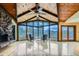 Bright living room with a stone fireplace and wall of windows, offering stunning views of the surrounding landscape at 994 Timber Ln, Boulder, CO 80304