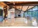 Elegant living space with a stone fireplace, wood ceilings, and large windows offering scenic views and spacious layout at 994 Timber Ln, Boulder, CO 80304