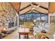 Cozy living room with a stone fireplace, vaulted ceilings, and expansive windows offering breathtaking mountain views at 994 Timber Ln, Boulder, CO 80304