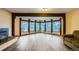 Bright living room featuring a fireplace, wood beams, wood floors, and large windows with scenic views at 994 Timber Ln, Boulder, CO 80304