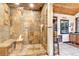 Beautiful bathroom shower featuring stone-tiled walls, glass enclosure, and rustic wood accents at 994 Timber Ln, Boulder, CO 80304