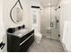 Modern bathroom featuring a floating vanity, round mirror, and walk-in shower with textured tile at 418 Steele St, Denver, CO 80206